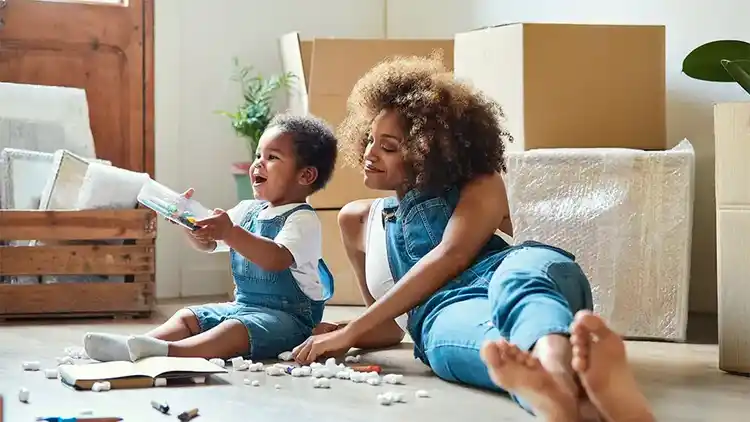 Une femme regarde son enfant jouer avec des flocons de styromousse.