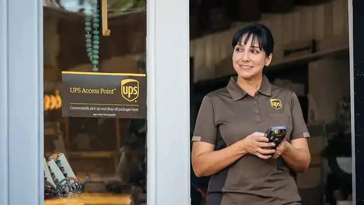 A UPS driver using a digital tablet at a UPS Access Point.