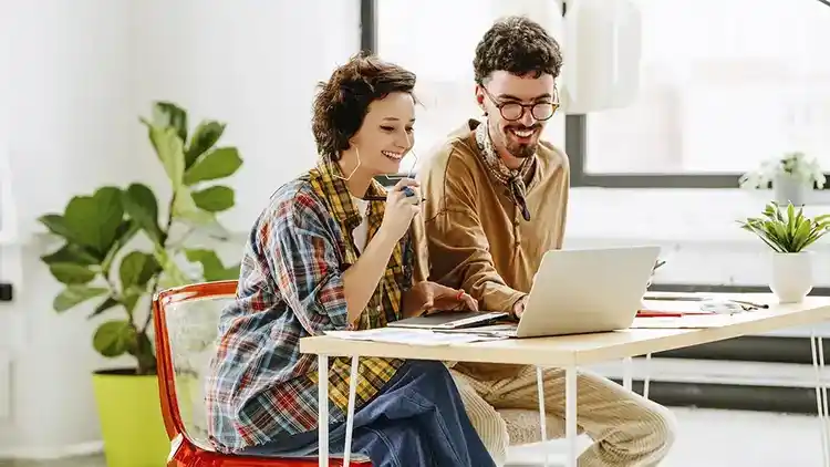 Two business owners smiling and getting a shipping discount with U-P-S.