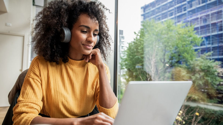 woman with headphones on listening to a virtual webinar