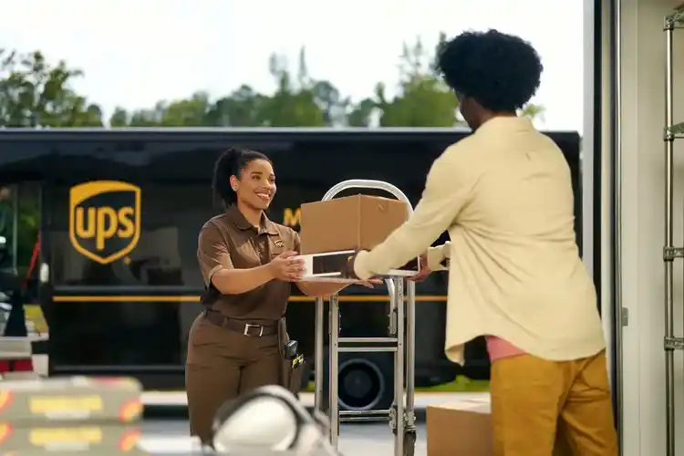 UPS driver handing a shipment to a happy customer.