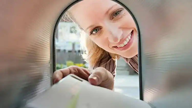 A person receiving mail from their mailbox.