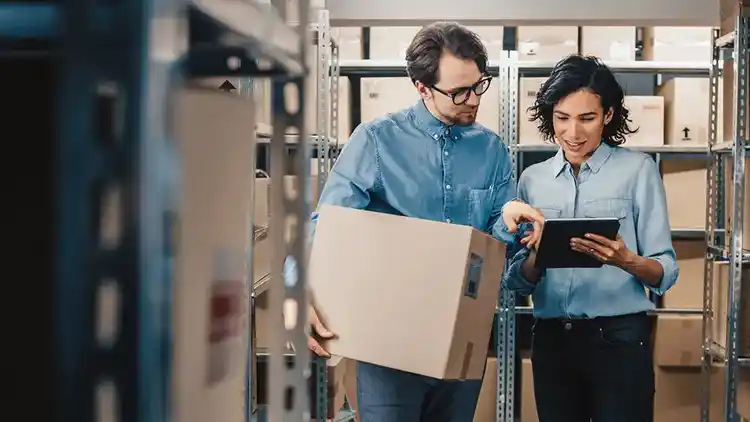 Dos personas sosteniendo una tableta y una caja