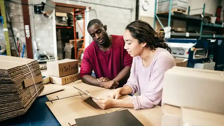 Hombre y mujer usando UPS WorldShip en una tableta.