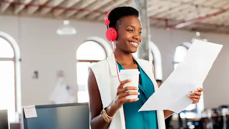 Mujer con auriculares revisando un documento