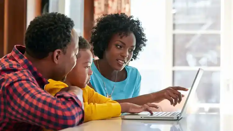 Una familia mira una computadora portátil